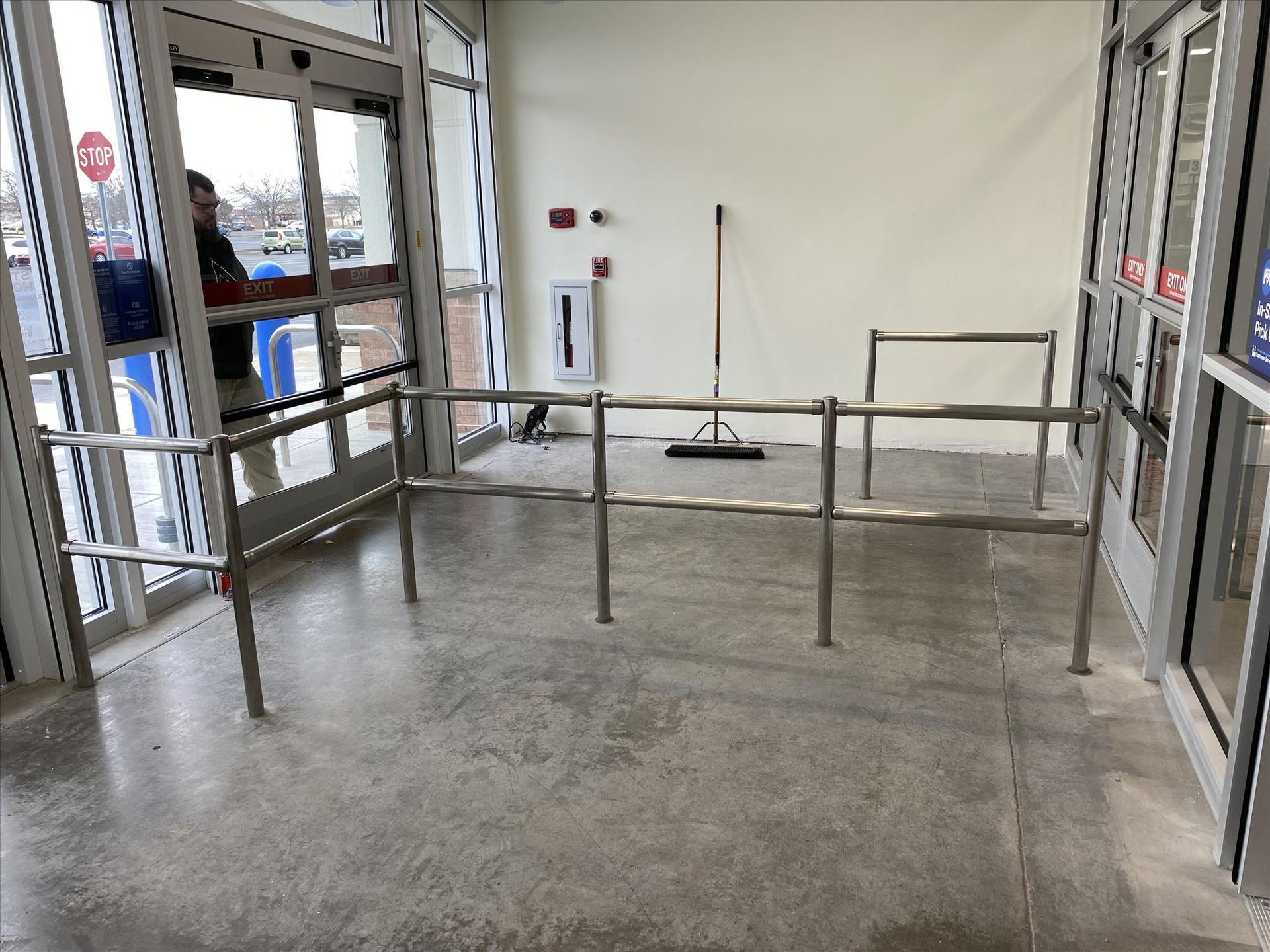 A stainless steel barrier is in front of a store entrance.