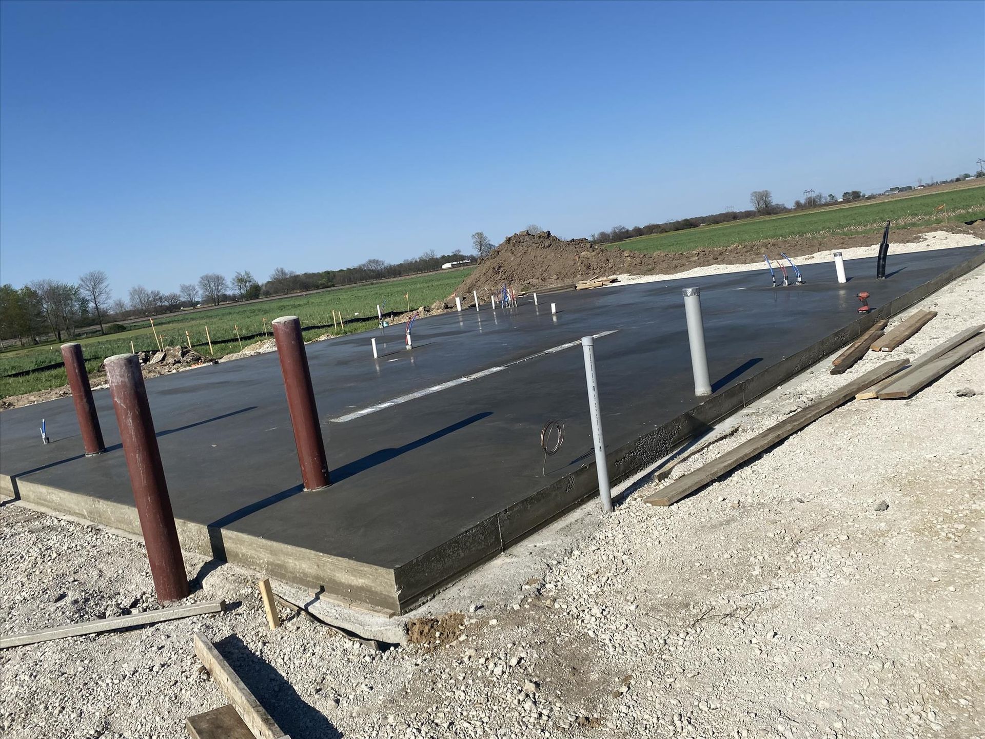 A concrete foundation is being built in a field.