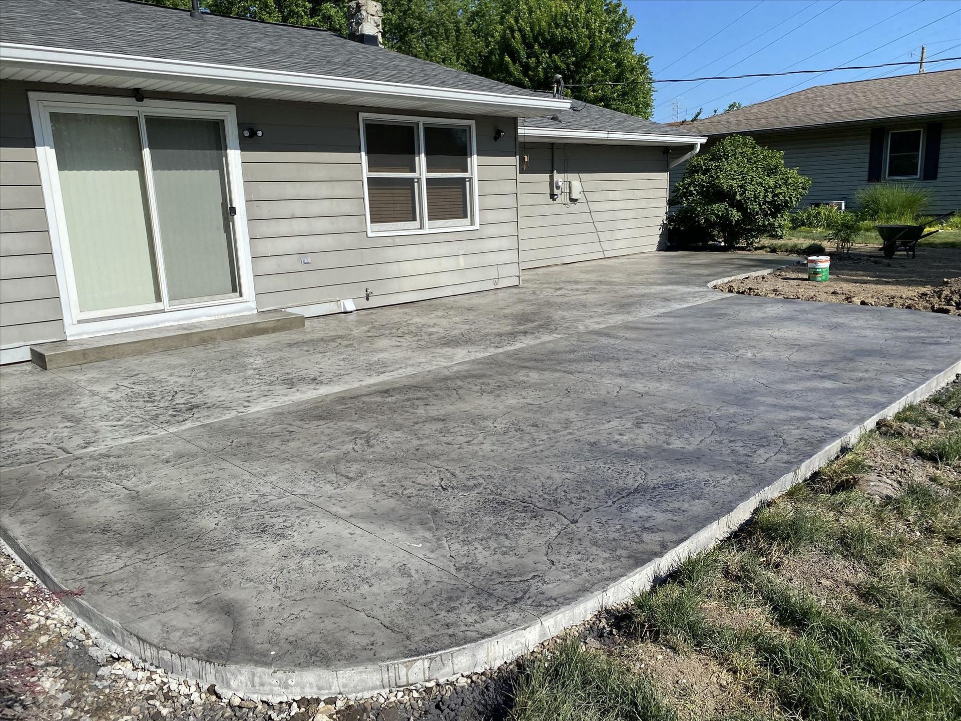 A concrete patio is being built in front of a house.