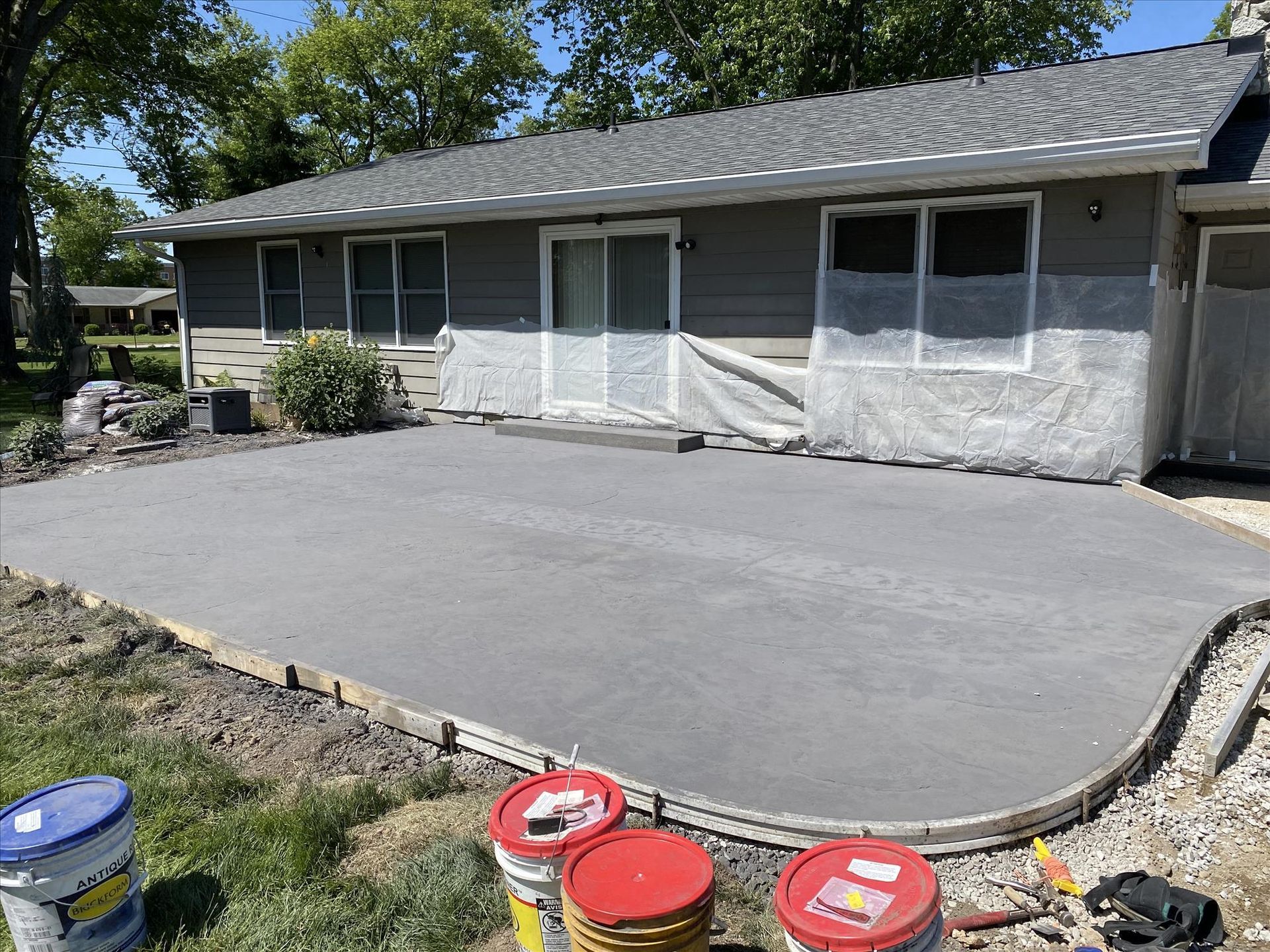 A concrete driveway is being built in front of a house.