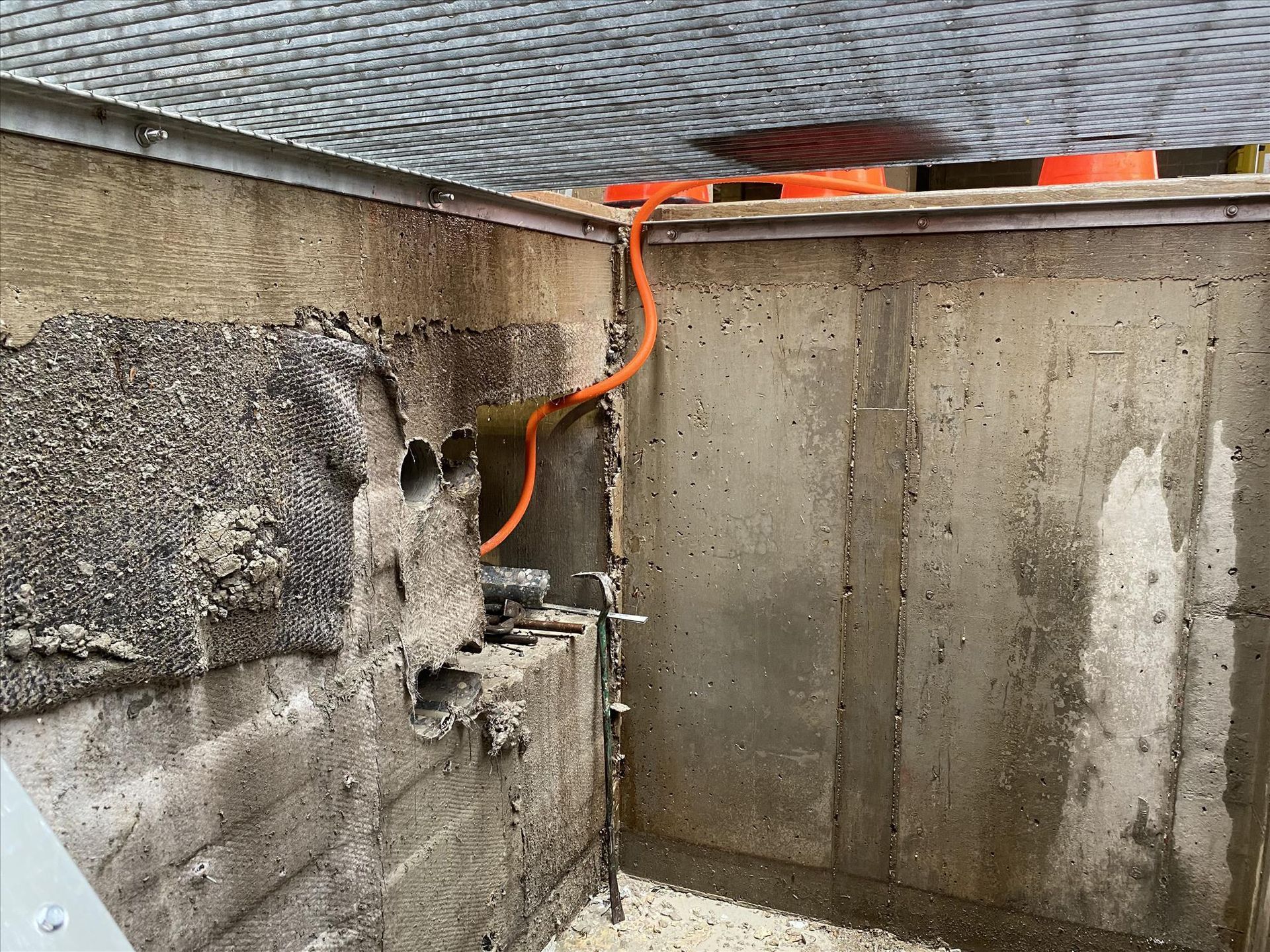 A concrete wall with a few wires coming out of it.