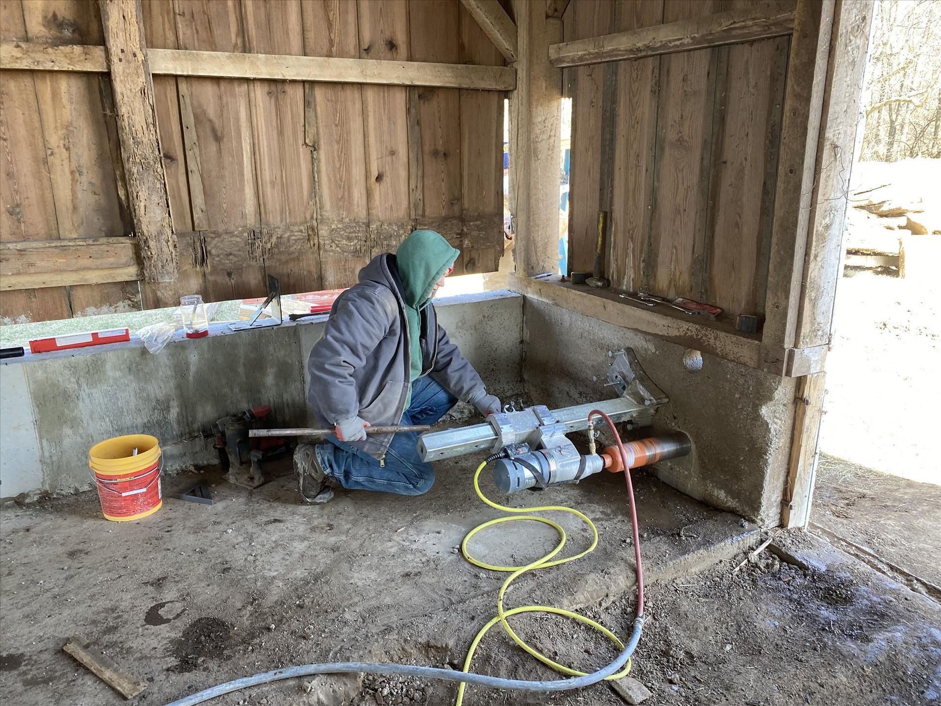 A man is working on a pipe in a wooden building.
