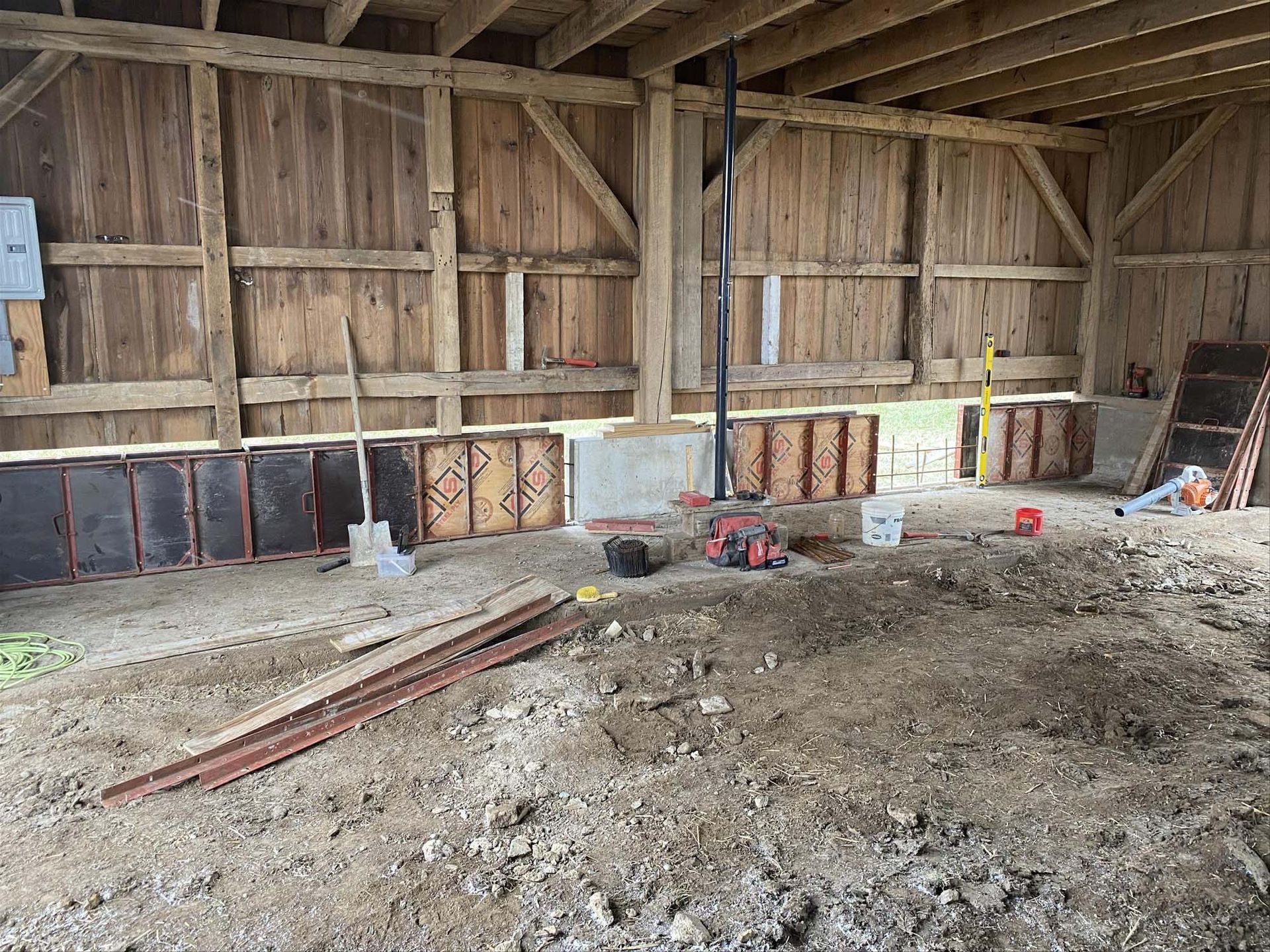 There is a lot of dirt in the middle of a barn.