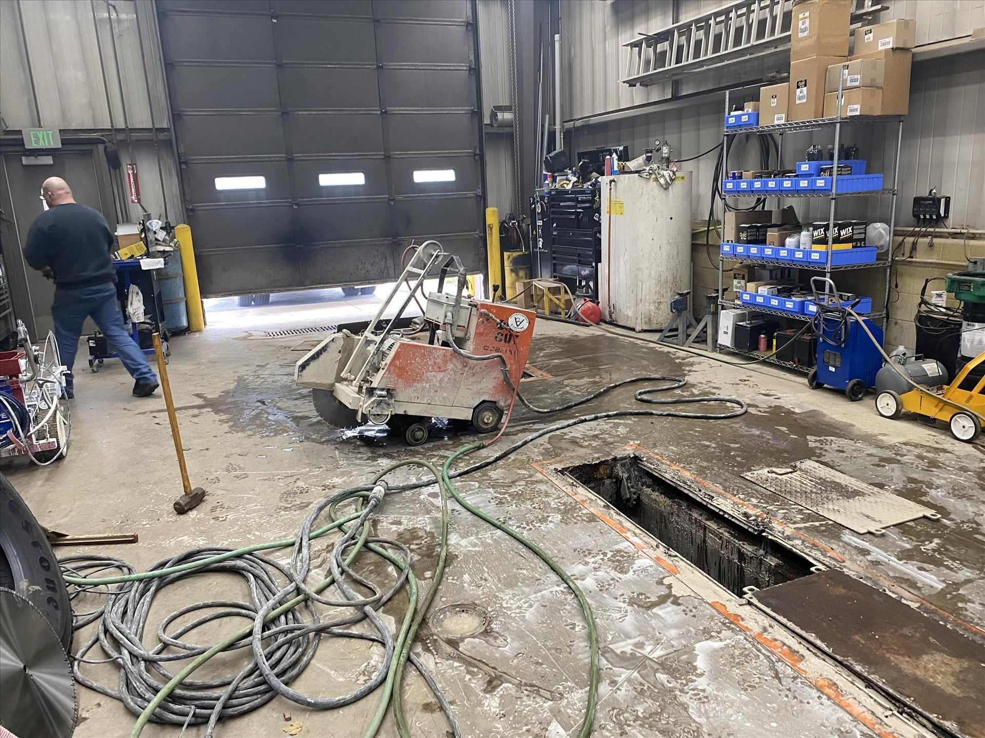 A man is working on a machine in a garage.