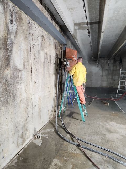 A man is cutting a hole in a wall with a machine.