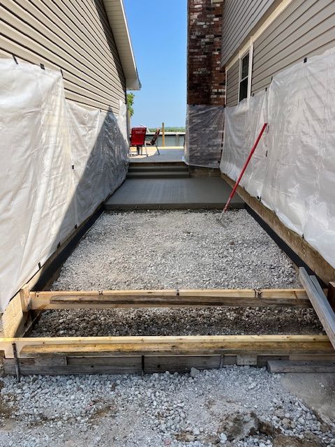 A concrete walkway is being built in front of a house.