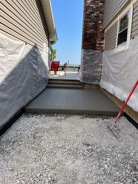 A concrete walkway is being built next to a house