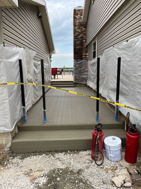 A concrete walkway is being built between two houses.