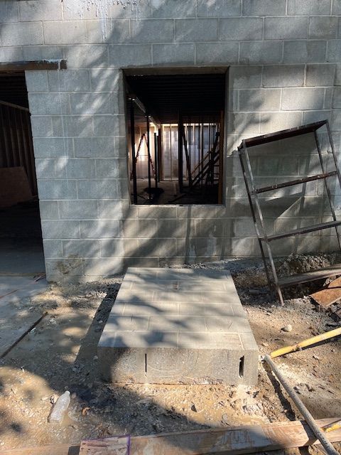 A brick wall with a window in it is being built.