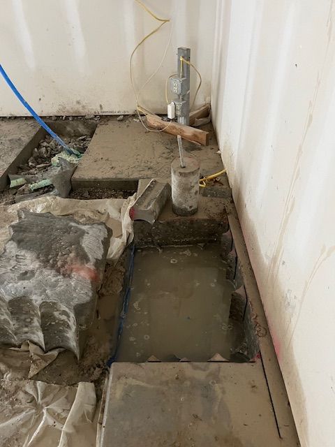 A hole in the floor is being filled with concrete.