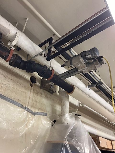 A bunch of pipes are hanging from the ceiling