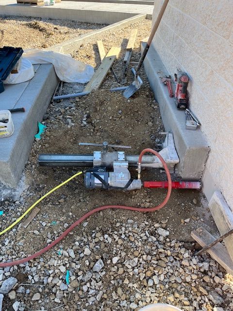 A hose is laying on the ground next to a pipe