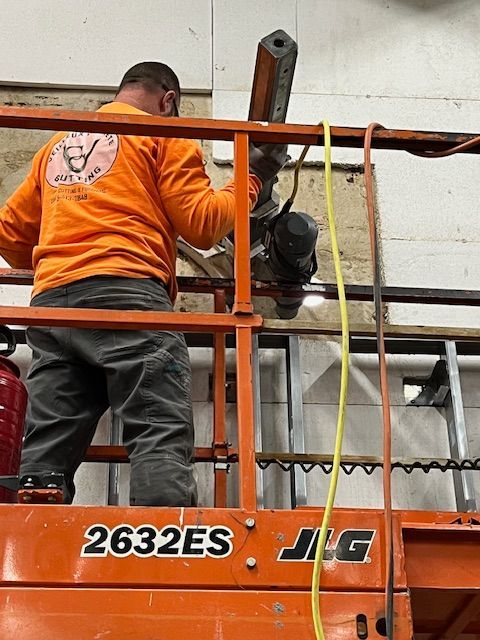 A man in an orange shirt is working on a jig lift