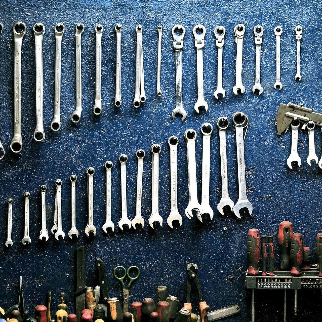 A bunch of wrenches are hanging on a wall