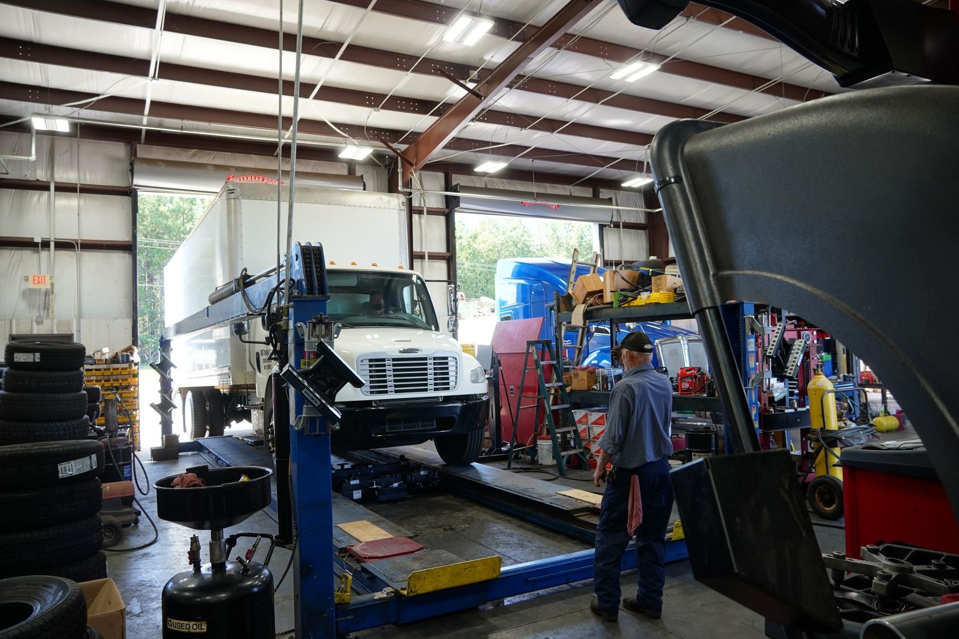 A man is working on a truck in a garage.