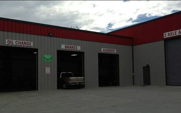 A truck is parked in front of a building that says oil change