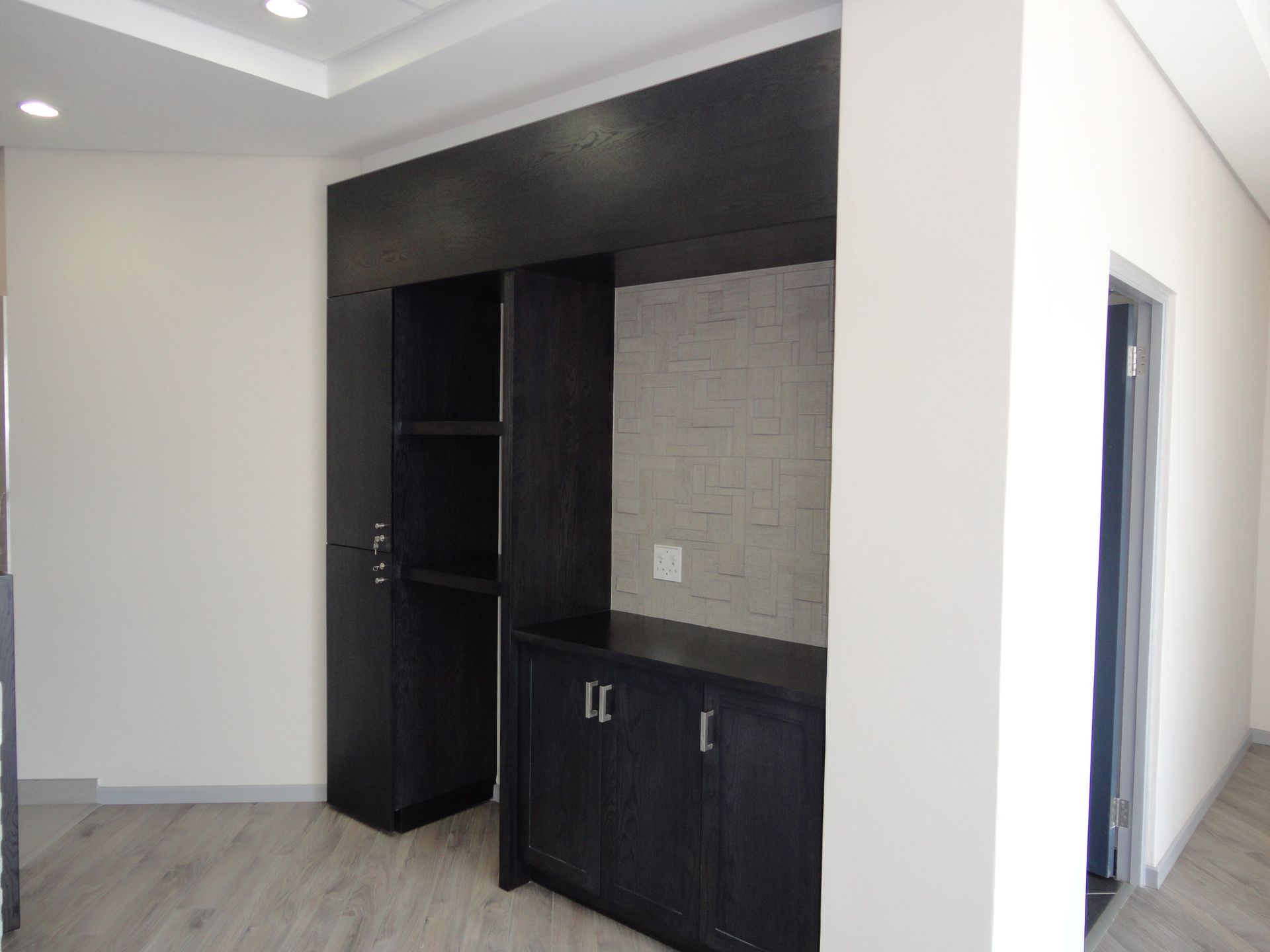 An Empty Room With Black Cabinets And White Walls — Nyon Shopfitters in Morisset, NSW