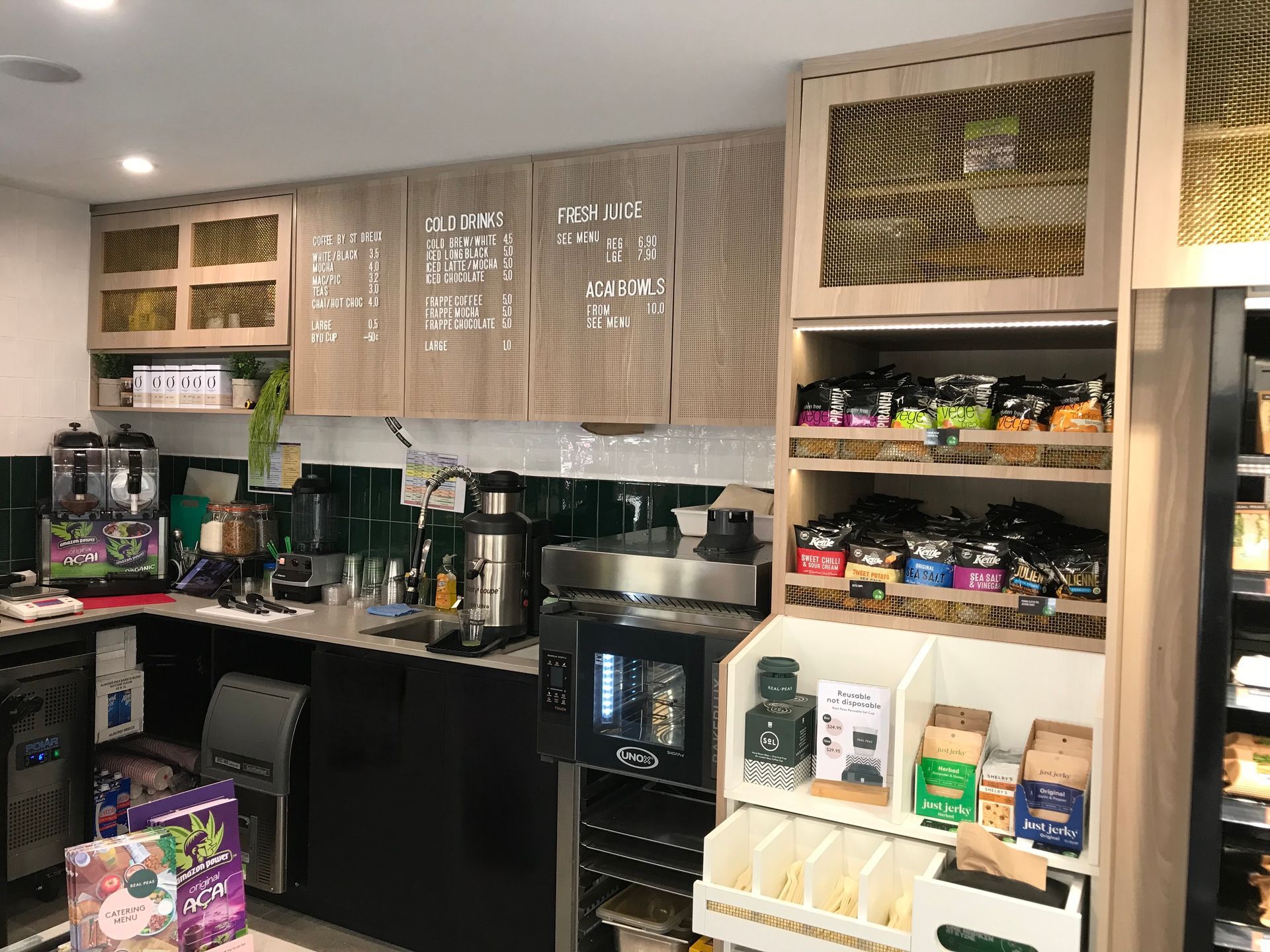 A Kitchen With Wooden Shelves And Cabinets Filled With Food — Nyon Shopfitters in Morisset, NSW