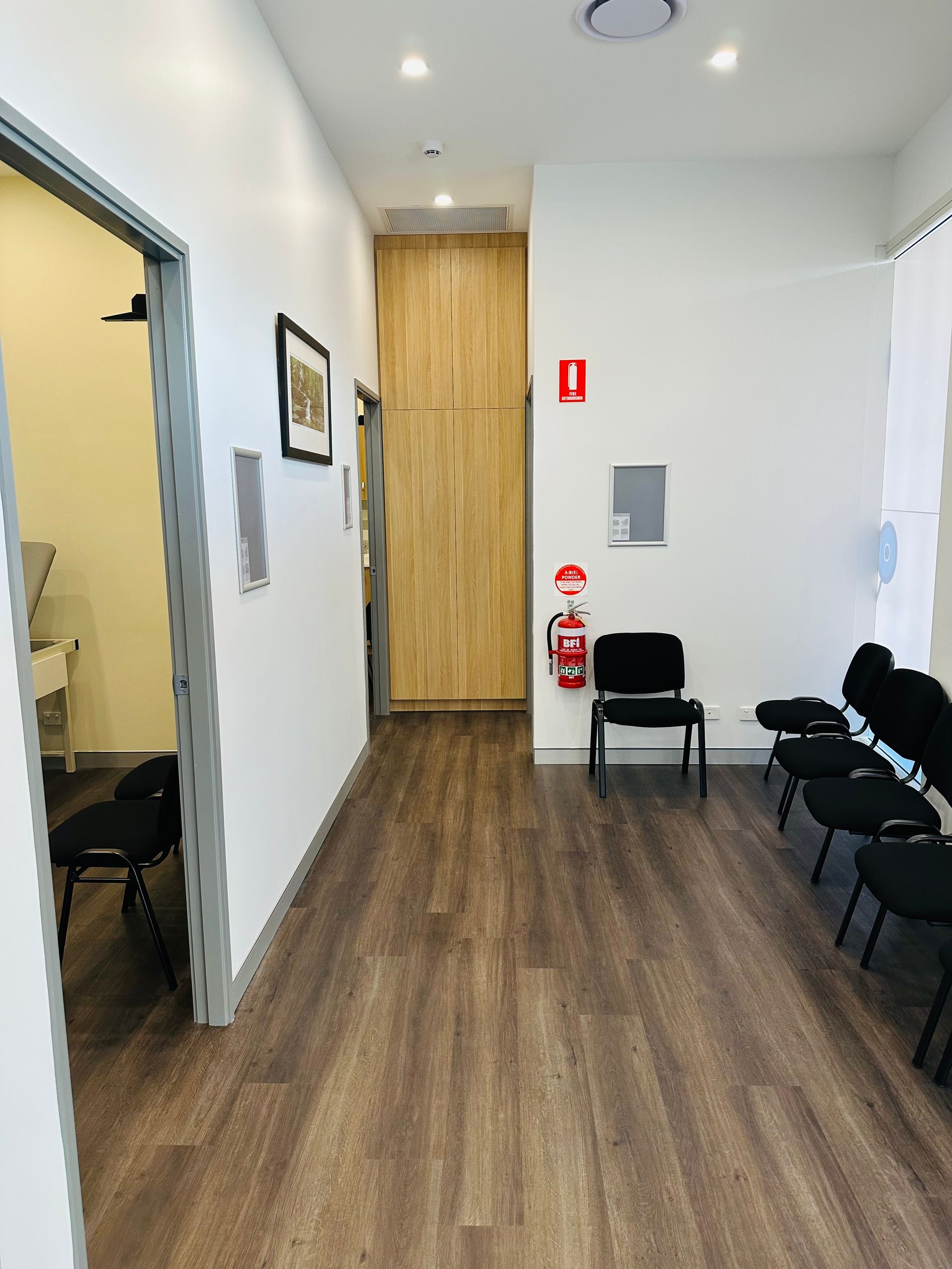 A Long Hallway With Chairs And A Fire Extinguisher On The Wall — Nyon Shopfitters in Morisset, NSW