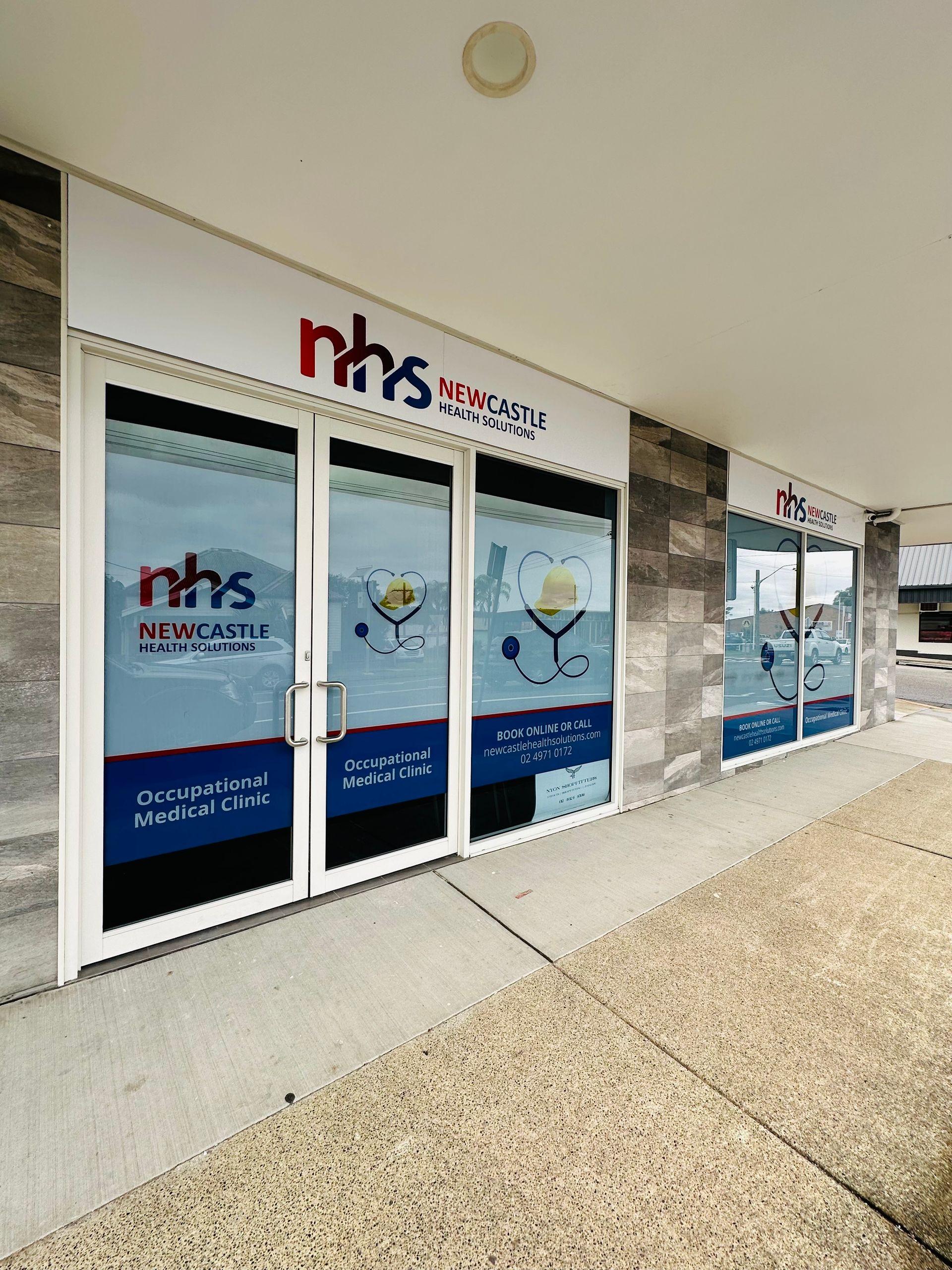 A Building With A Sign That Says NHS On It — Nyon Shopfitters in Morisset, NSW