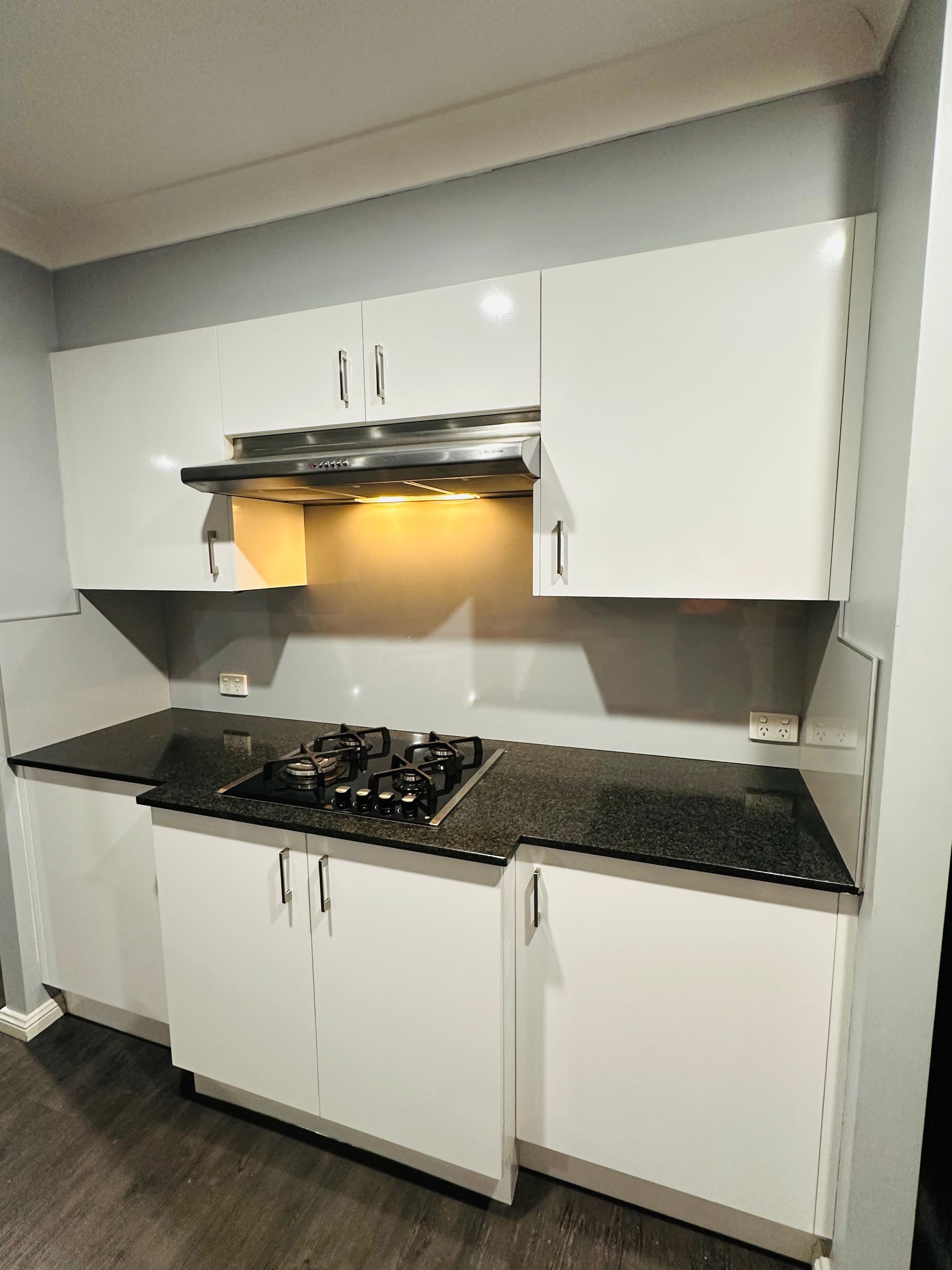A Kitchen With A Gas Stove and Black Counter Top — Nyon Shopfitters in Morisset, NSW