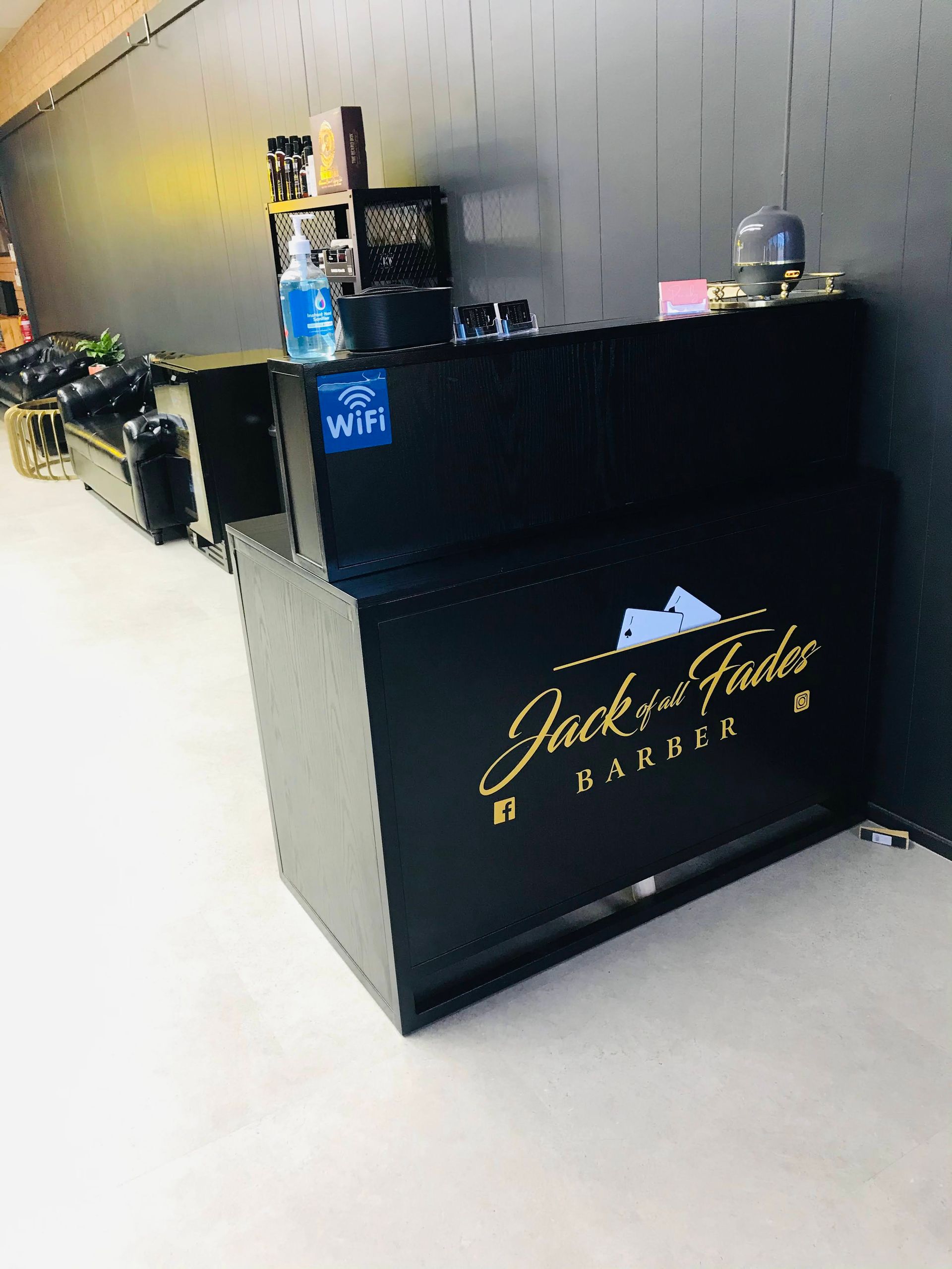 A Black Counter in a Barber Shop With a Gold Logo — Nyon Shopfitters in Morisset, NSW