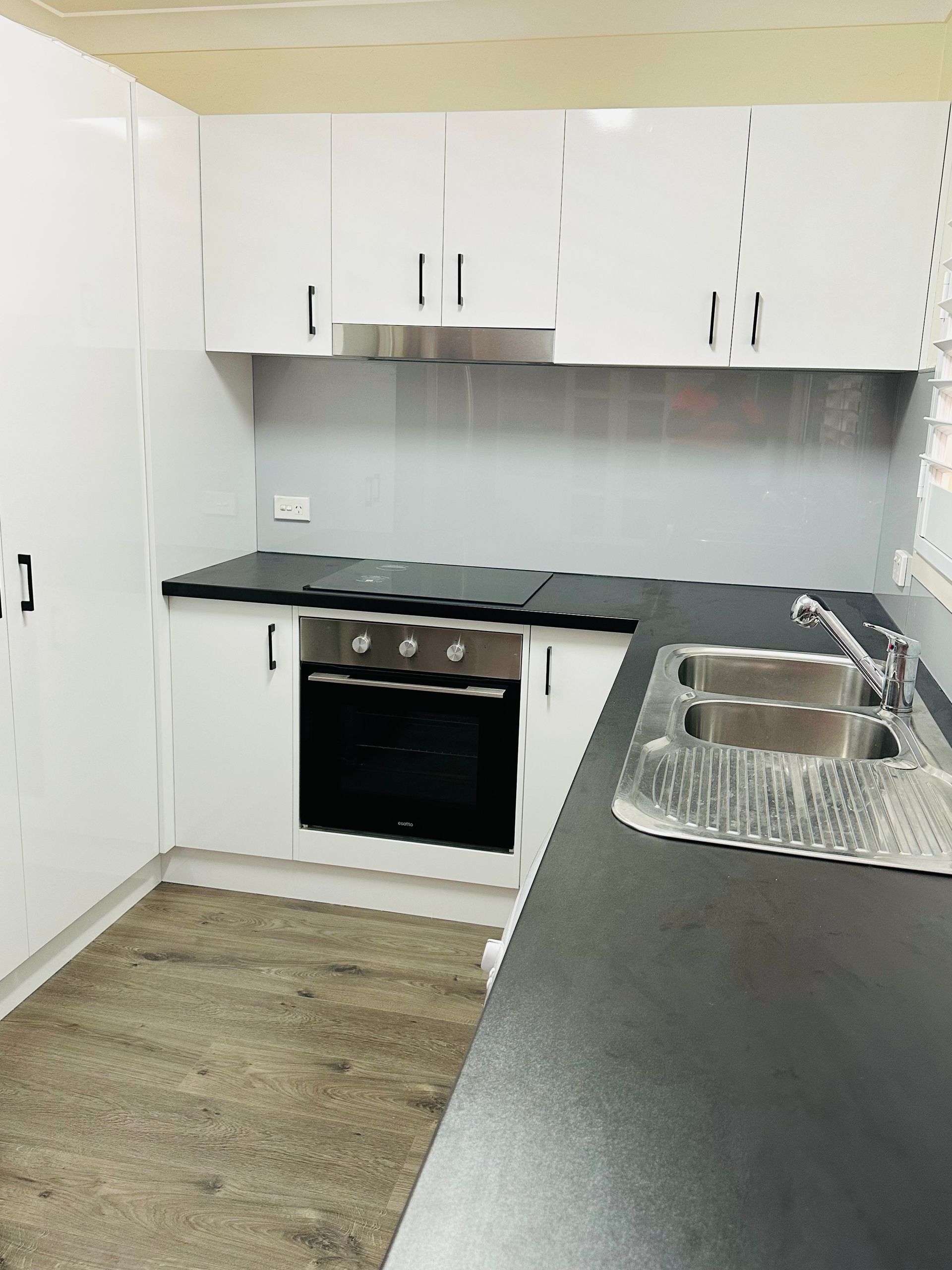 A Kitchen With Black Counter Tops, An Oven And A Sink — Nyon Shopfitters in Morisset, NSW