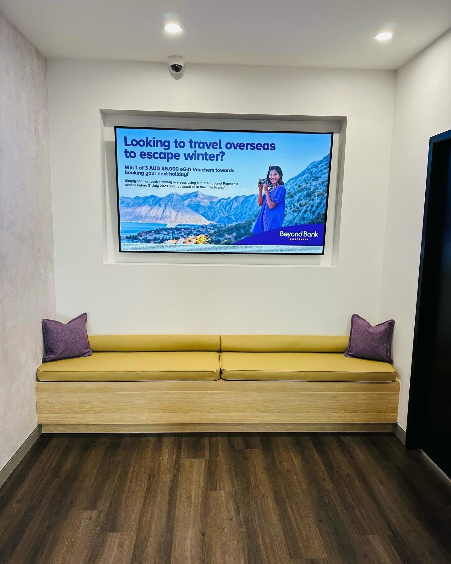 A Waiting Room With a Couch and a Sign That Says Looking to Travel Overseas — Nyon Shopfitters in Morisset, NSW