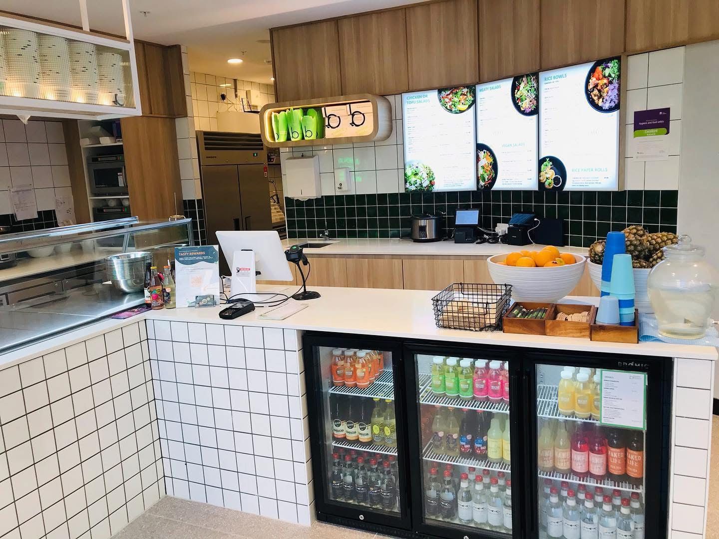 A Restaurant Kitchen With A Counter And A Refrigerator Filled With Drinks — Nyon Shopfitters in Morisset, NSW
