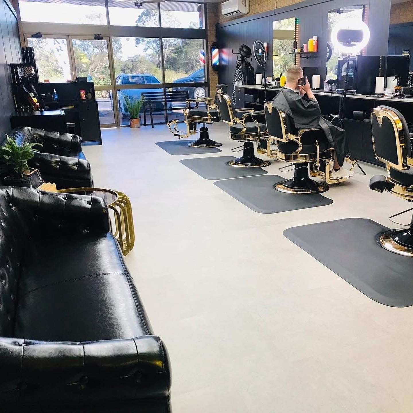 A Man is Sitting in a Barber Chair in a Barber Shop — Nyon Shopfitters in Morisset, NSW