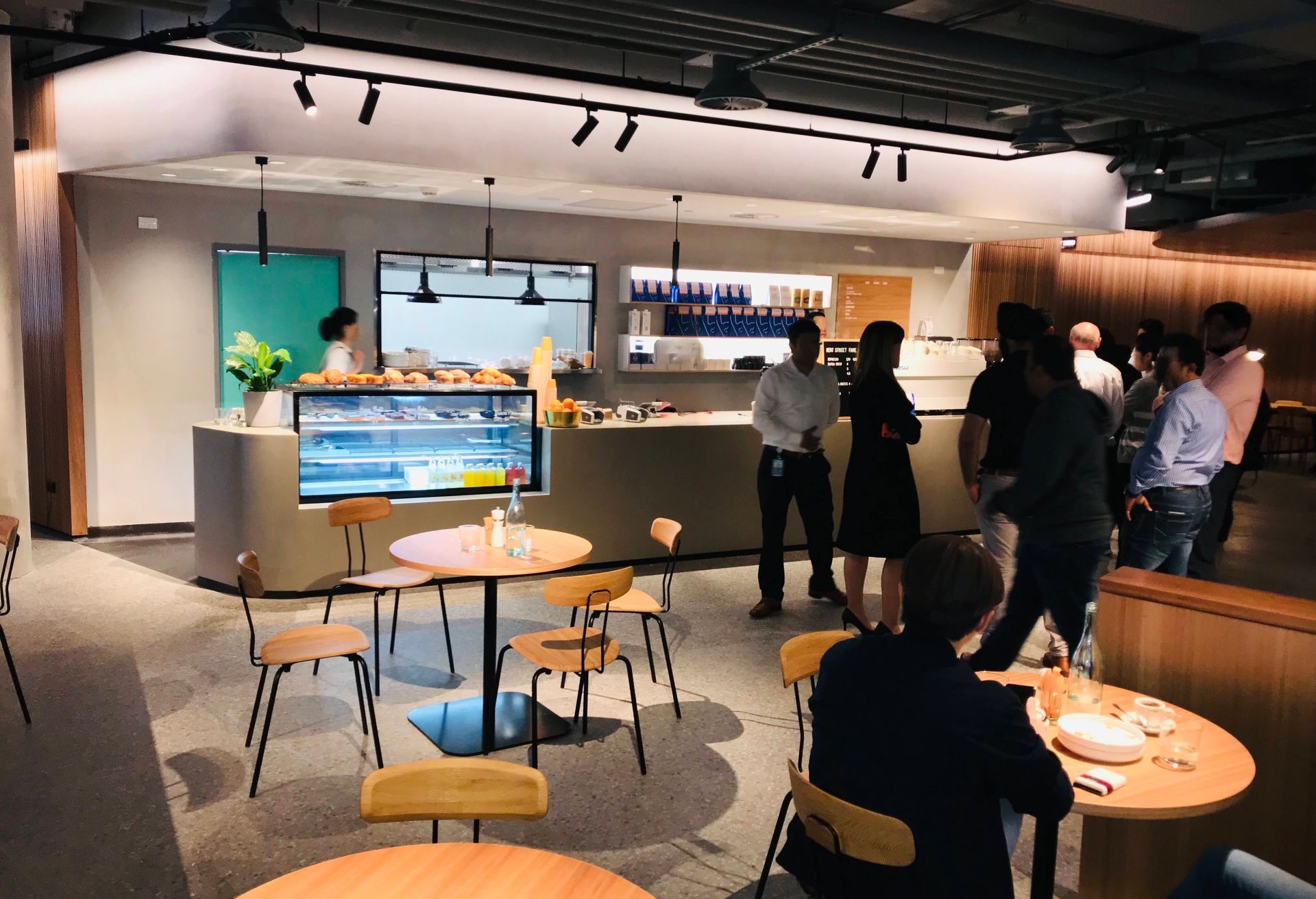A Group of People Are Sitting At Tables in a Restaurant — Nyon Shopfitters in Morisset, NSW