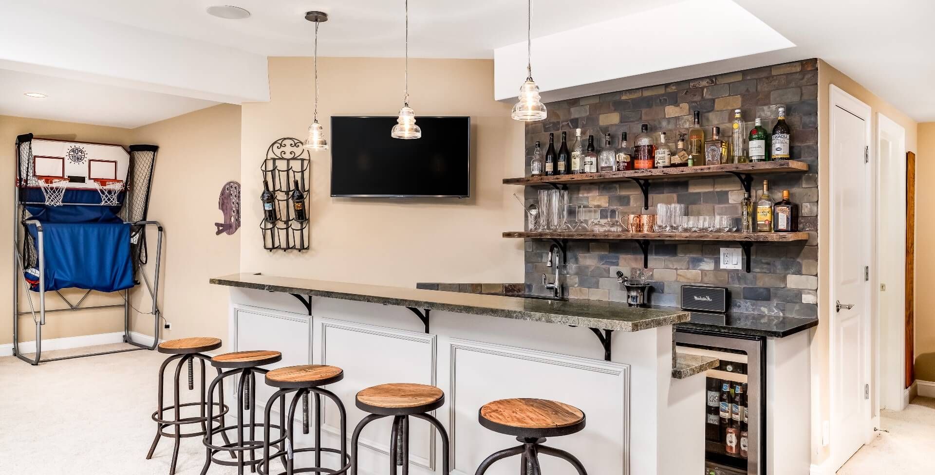 A bar, bar stools, TV, and a portable basketball court  are essential for an epic man cave