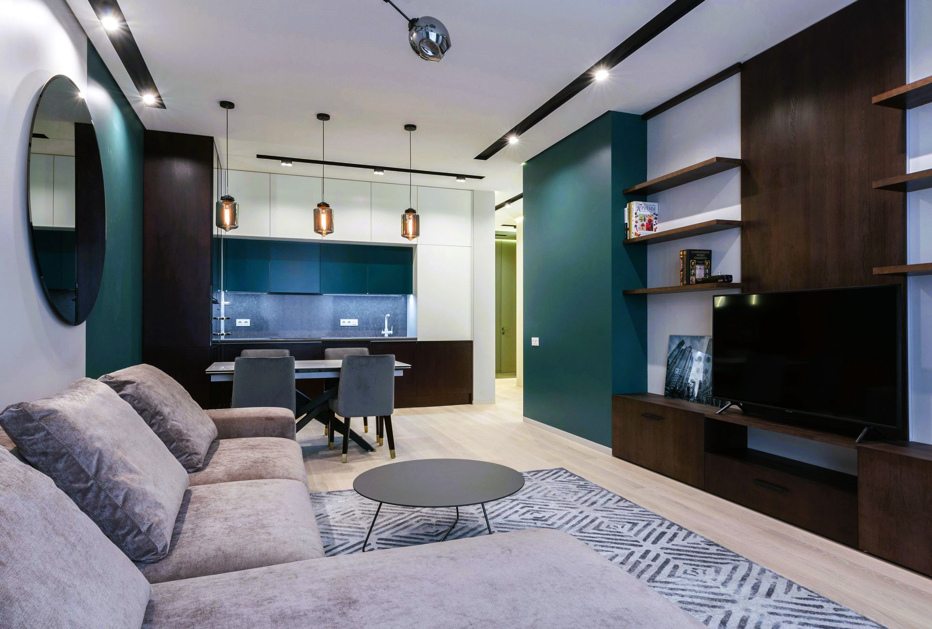 Basement living room with midnight green accent wall, couch, and wooden furniture near kitchen