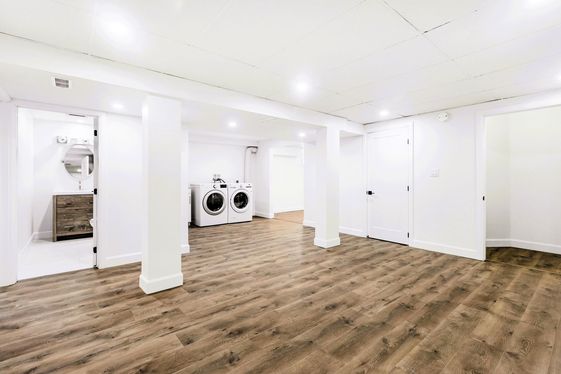 Basement room with white walls featuring a washing machine in the corner