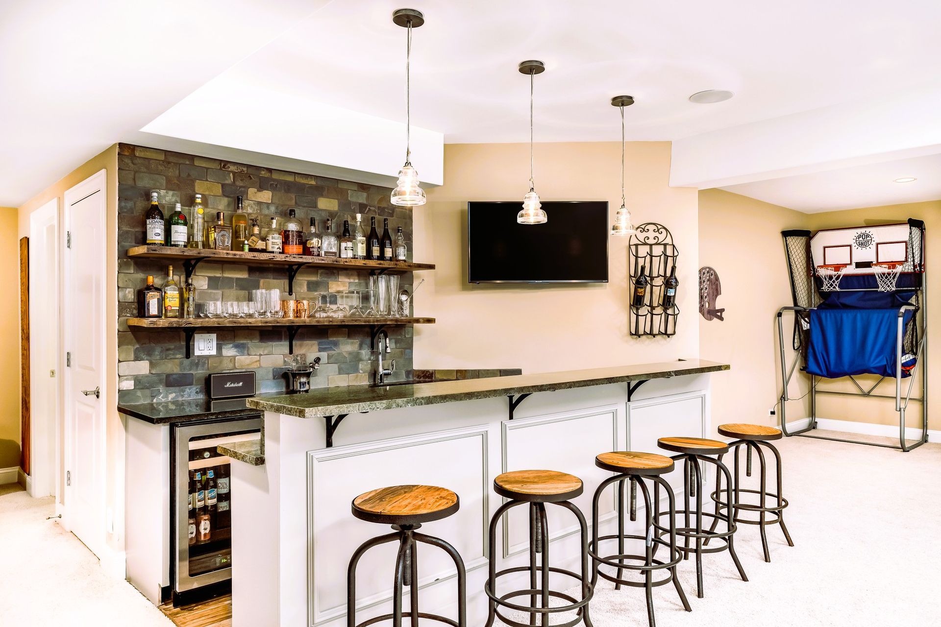 basement mini bar with granite countertop and basketball game