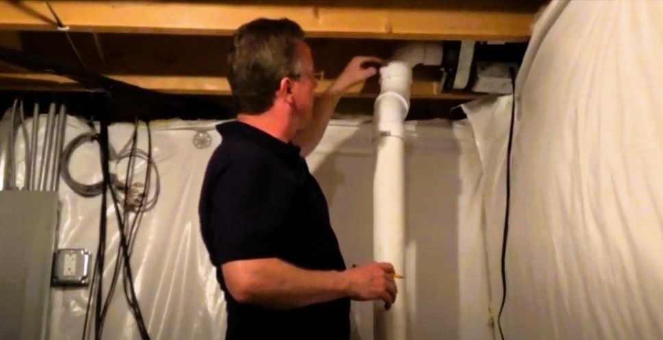 Expert examining a basement to install ventilation system