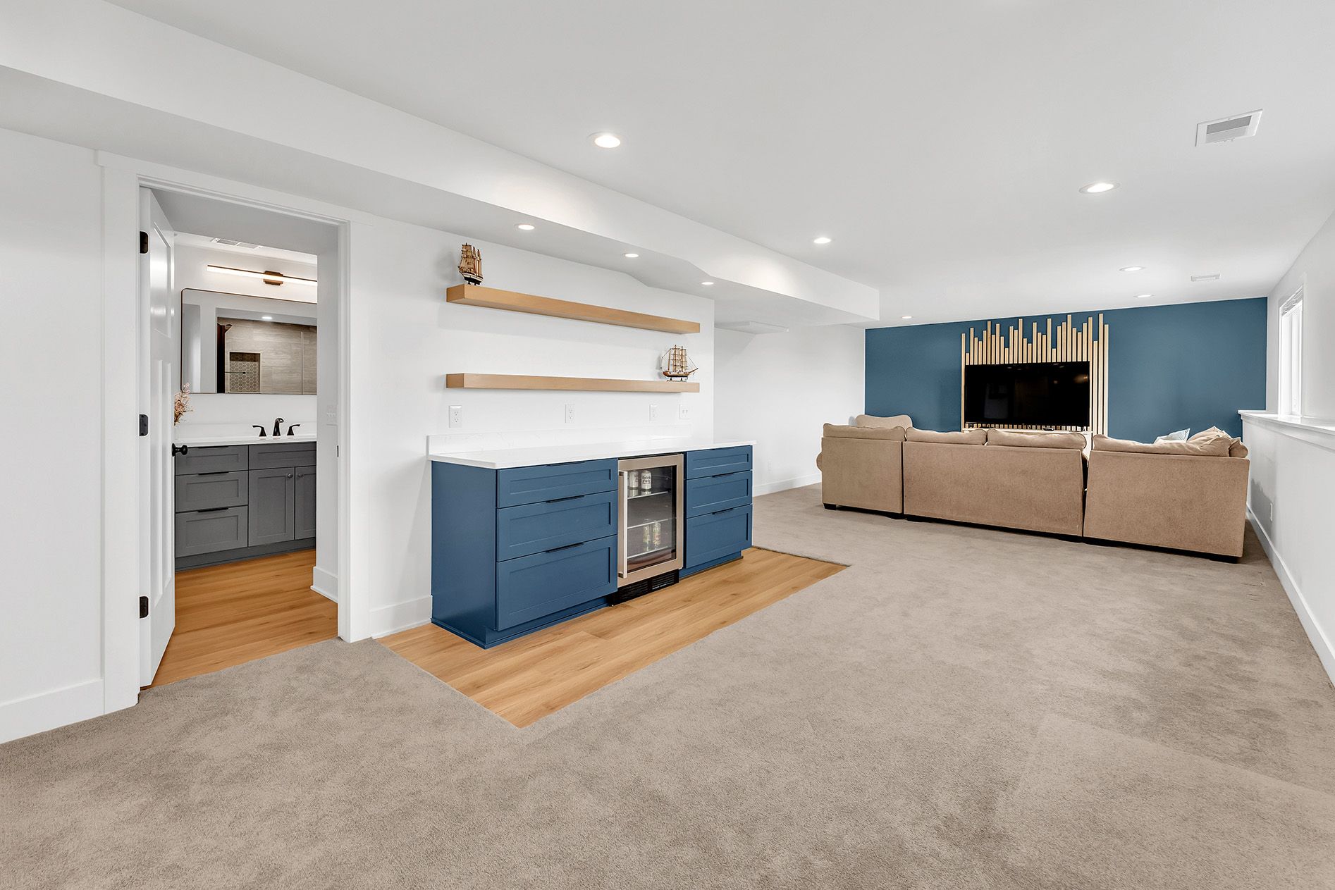A living room with a dry bar , couch , and television.