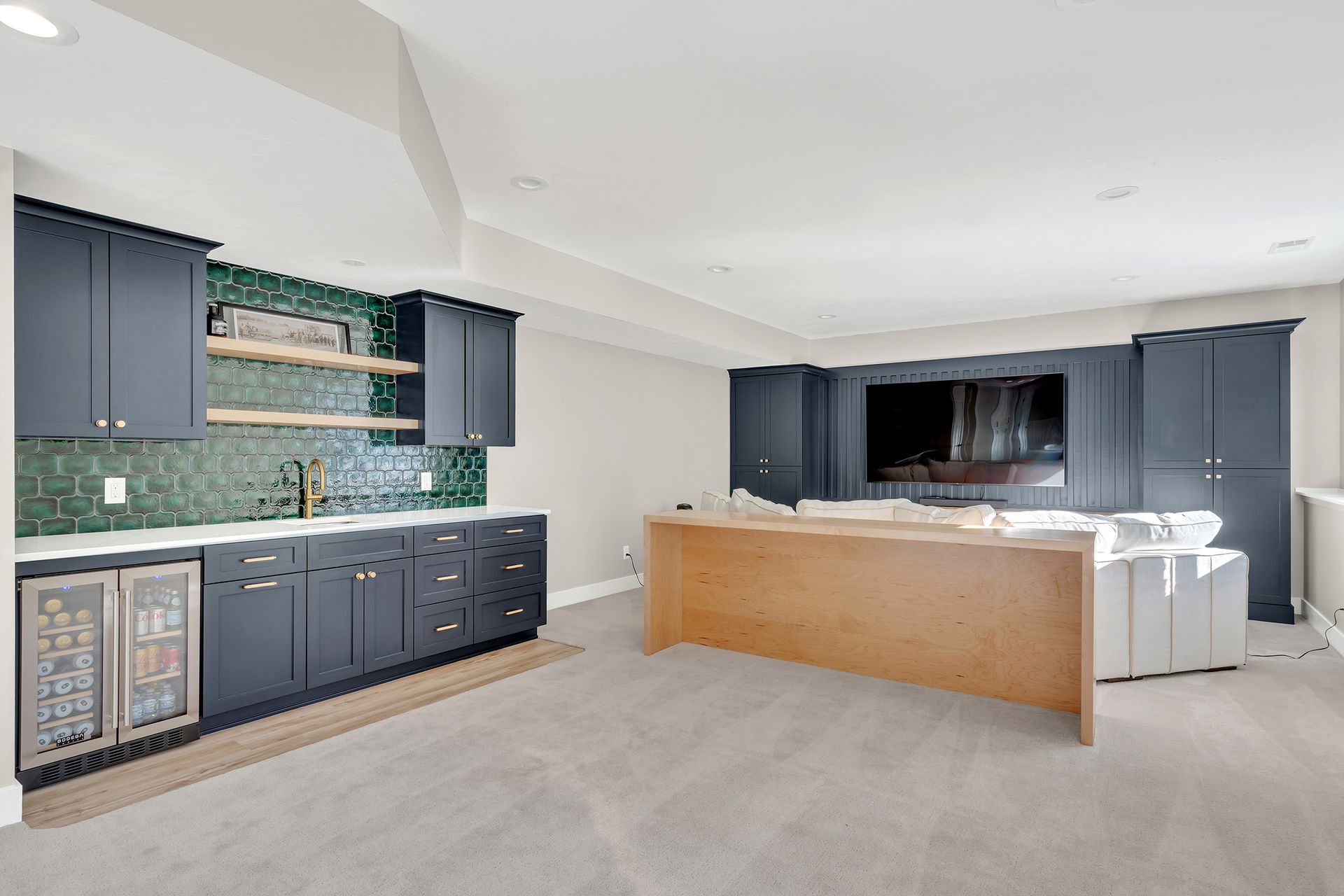 A basement with a bar , couch , and television.