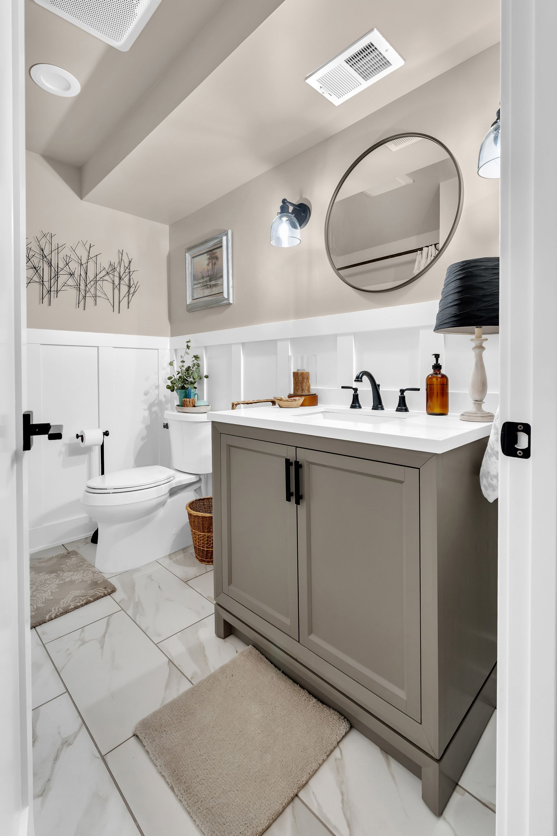 A bathroom with a sink , toilet and mirror.
