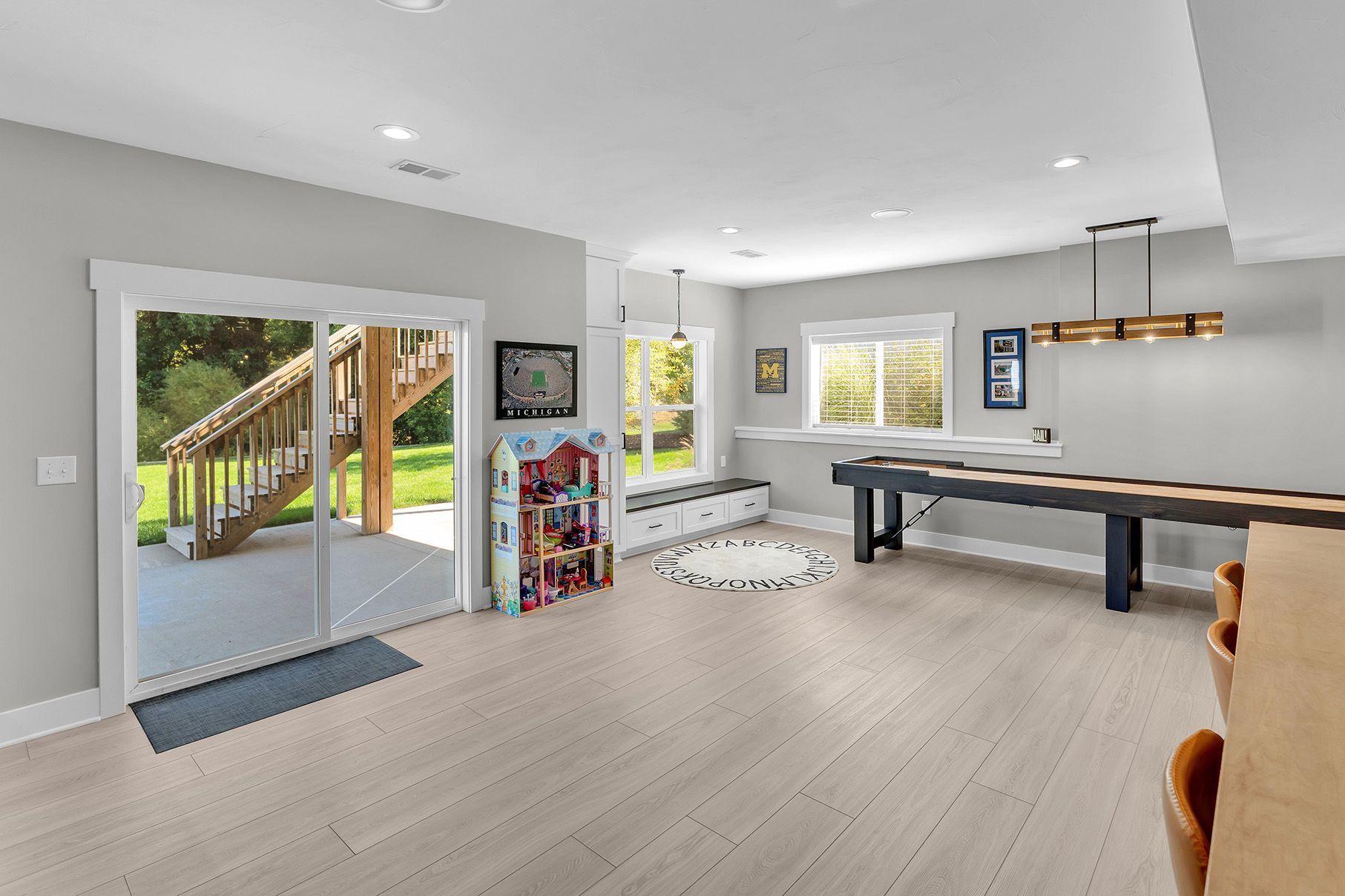 A rec room with a pool table and sliding glass doors leading to a walkout basement.