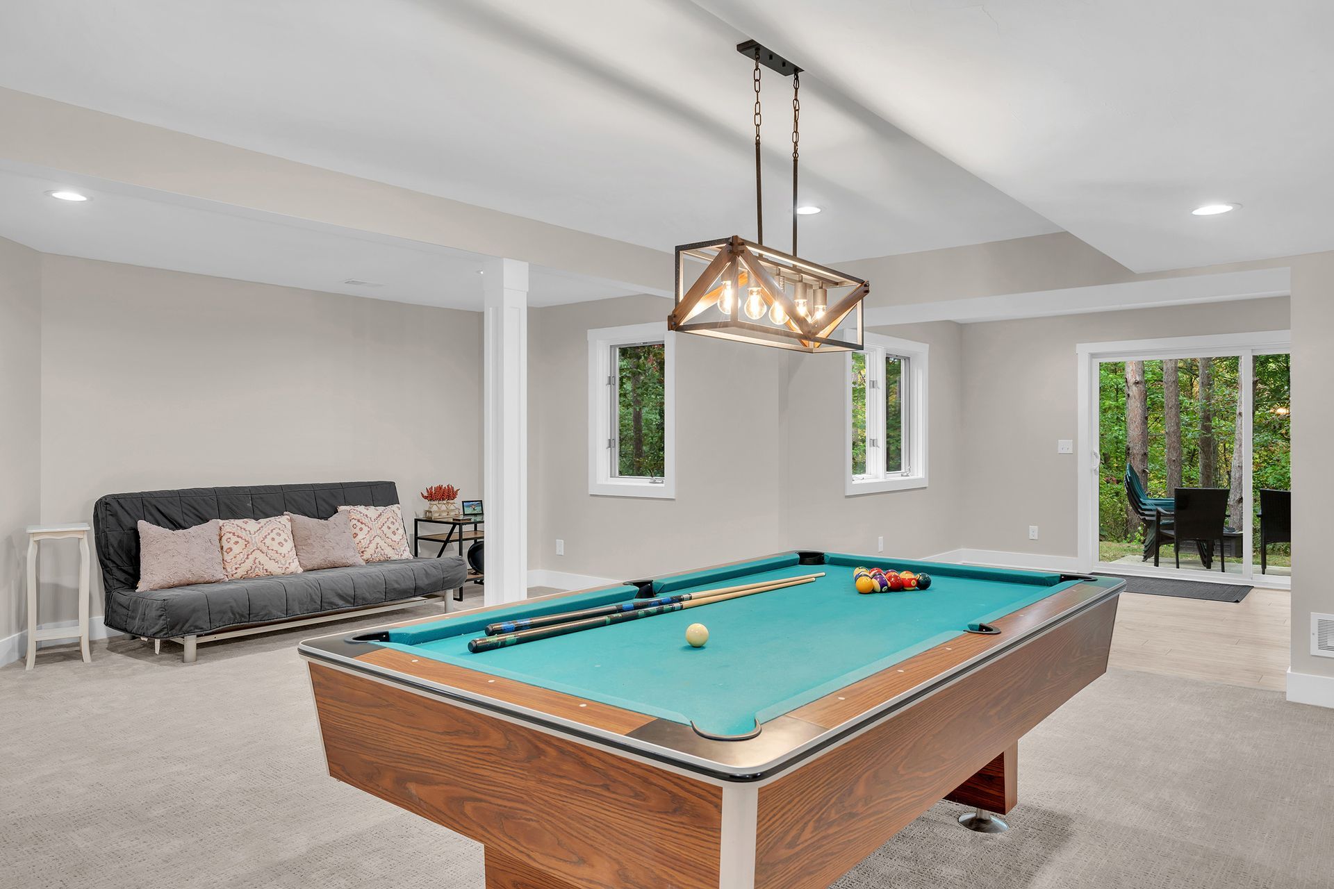 There is a pool table in the middle of the rec room.