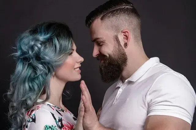Couple facing and looking each other eyes to eyes while smiling.