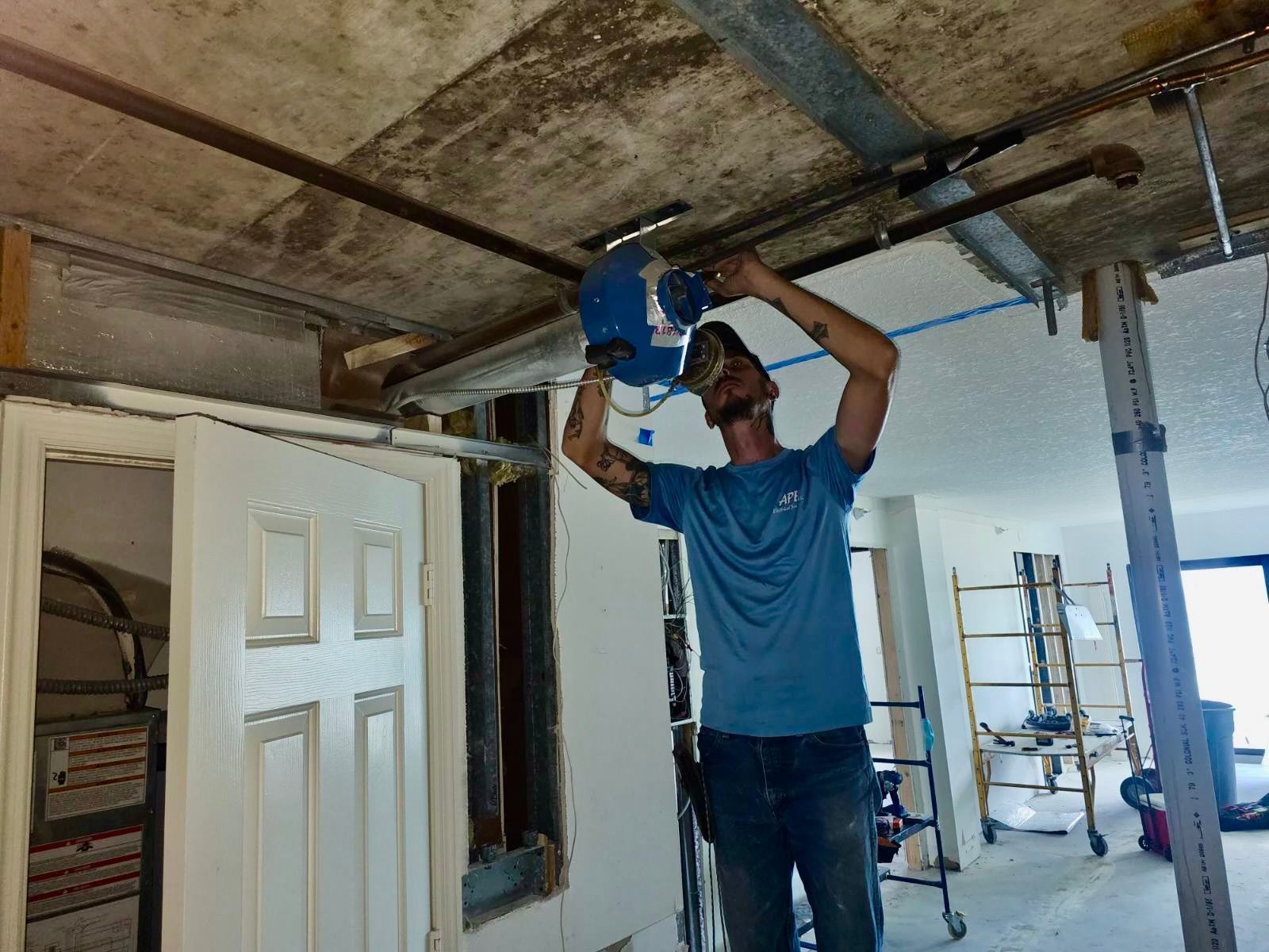 A man is working on a garage door in a room.