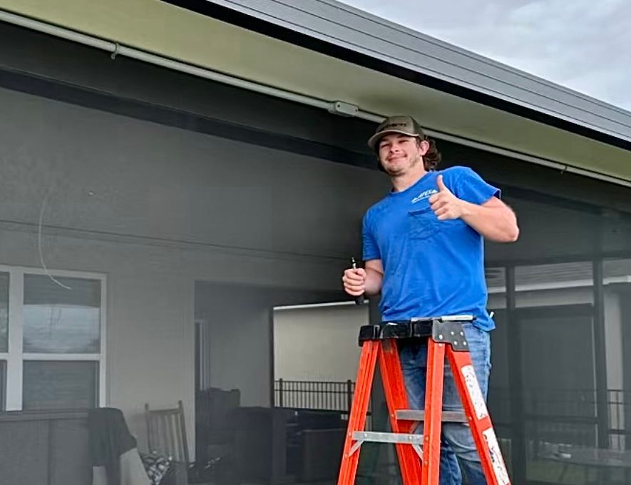 A man is standing on a ladder and giving a thumbs up.