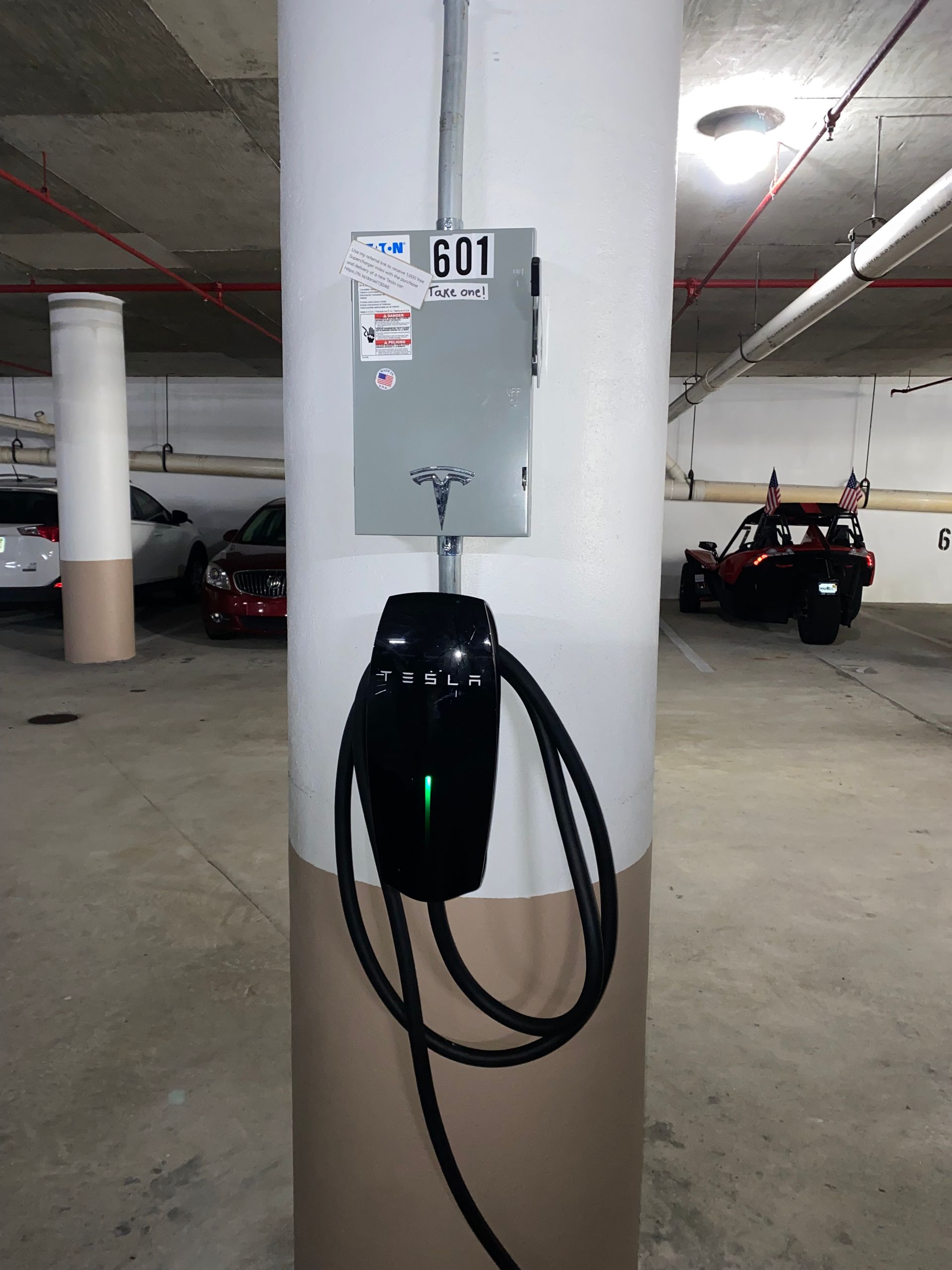 a car charger is attached to a pole in a parking garage