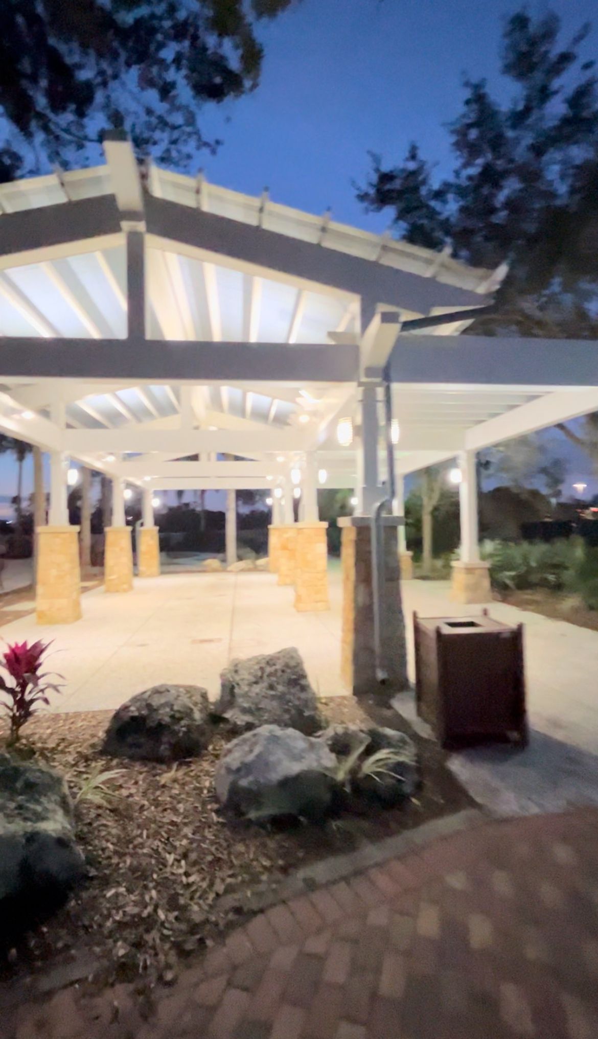 a large building with a covered walkway and a trash can in front of it .