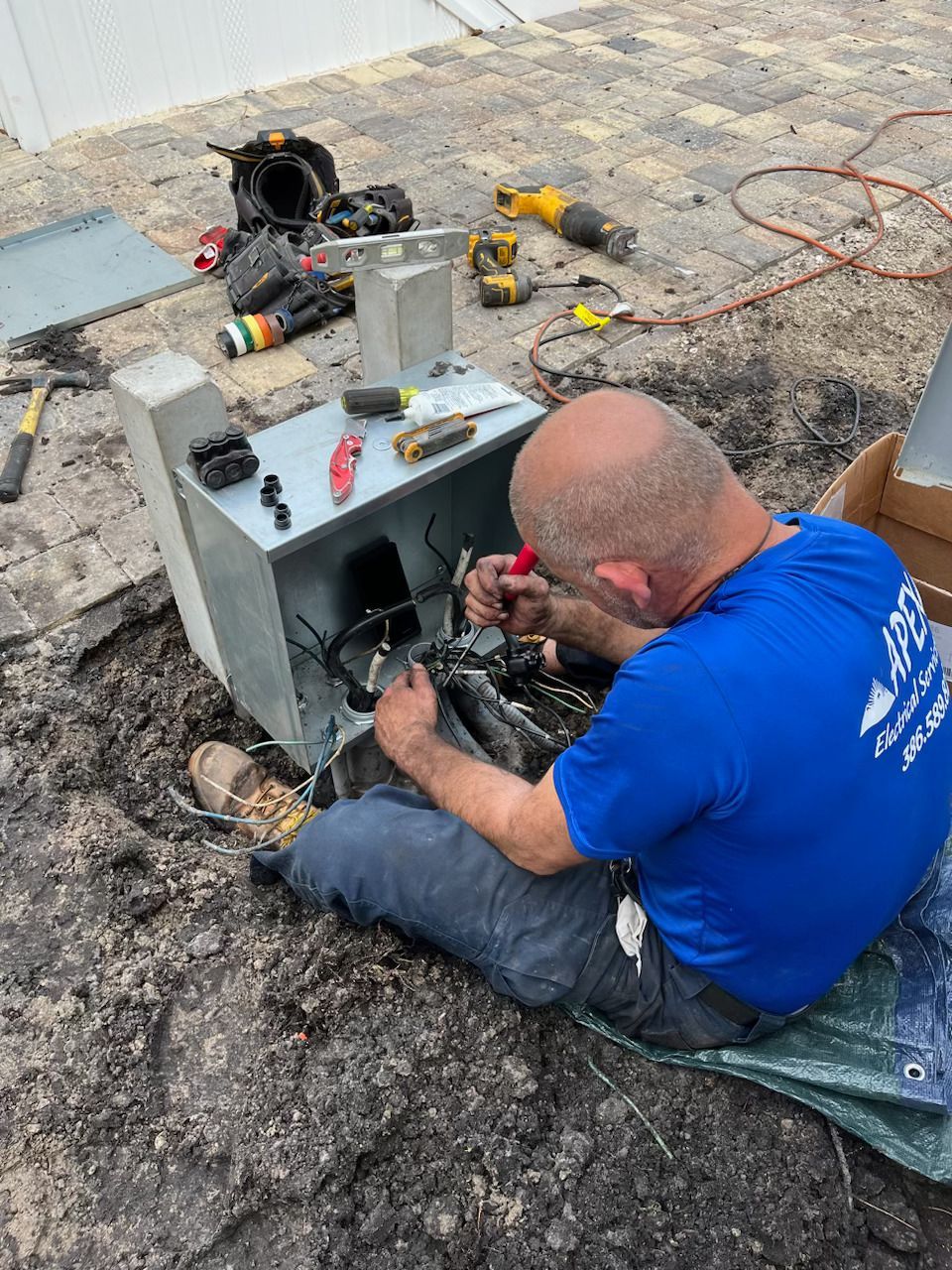 a man is sitting on the ground working on a machine .