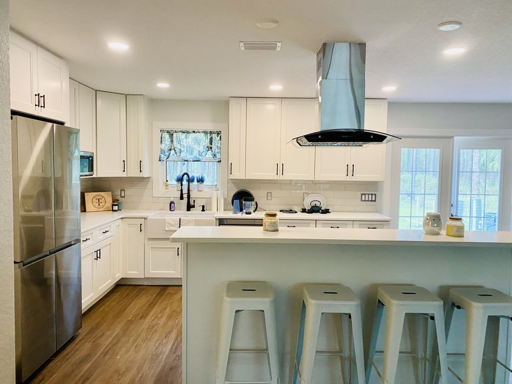 a kitchen with white cabinets and stainless steel appliances