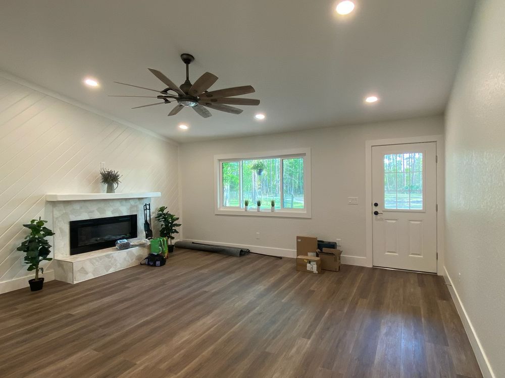 a living room with a fireplace and a ceiling fan .