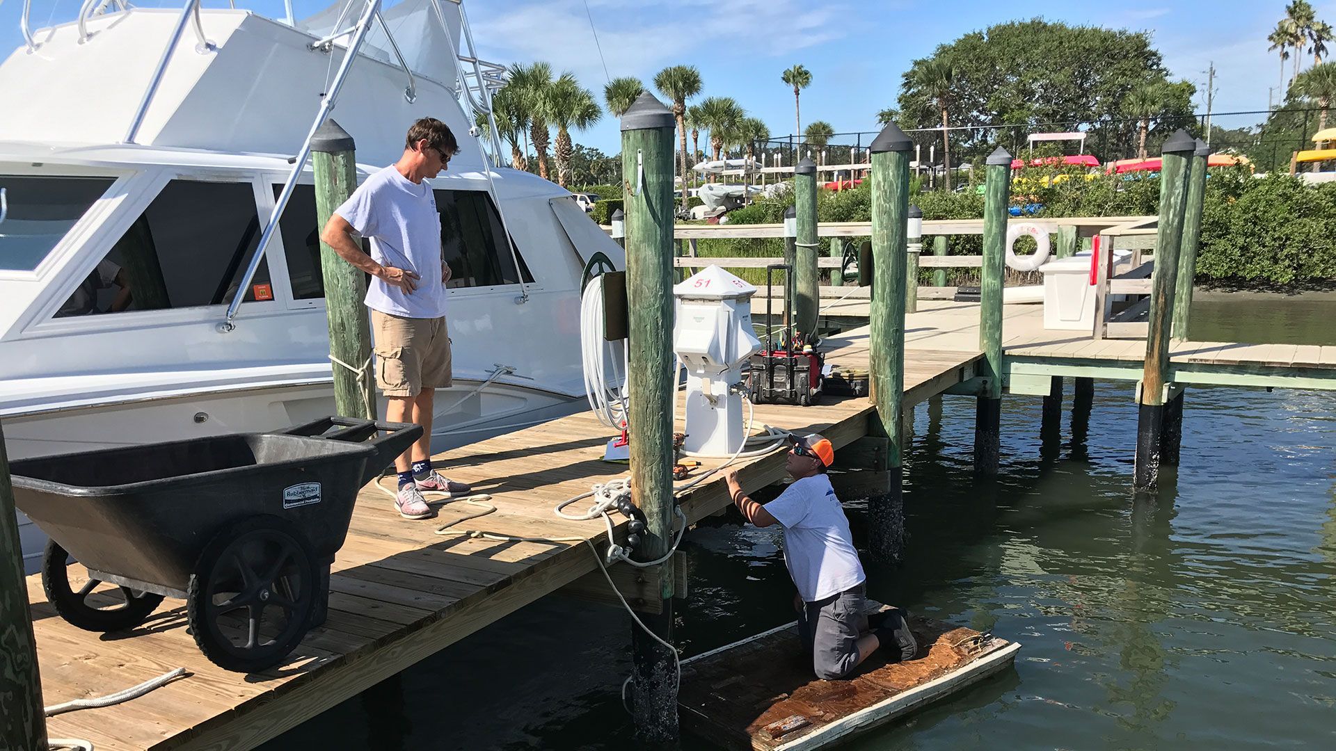 two men are working on a dock near a boat